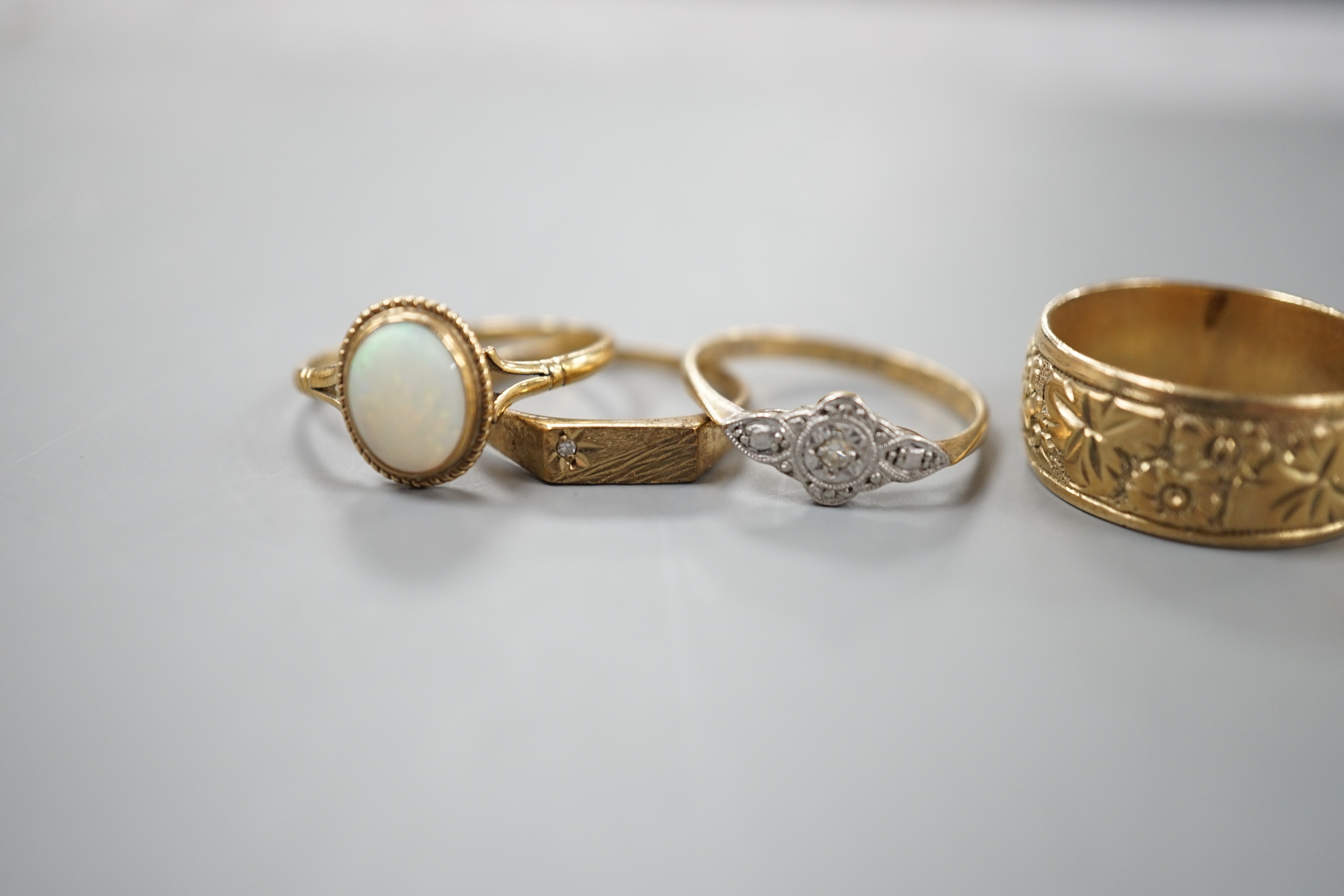 Four assorted 9ct rings, including band, white opal set, diamond chip set and millegrain diamond set, gross 11 grams.